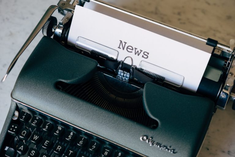 Une vieille machine à écrire du milieu du 20ème siècle avec une page en cours d'écriture où il est écrit "News" pour faire référence à la dernière newsletter du Bureau de la stratégie numérique.